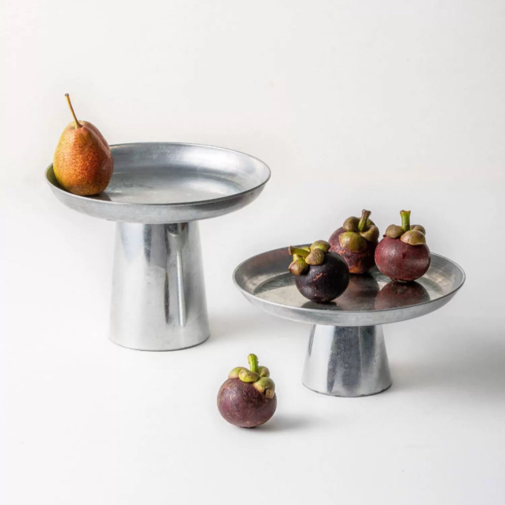 Metal cake stand with fruits on a white background
