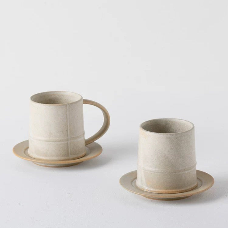 Two ceramic cups with saucers on a light gray background, featuring the brand 'ALANIZ'.