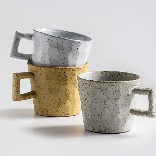 Three ceramic mugs with speckled textures and handles on a light gray background, featuring the brand 'Alaniz'.