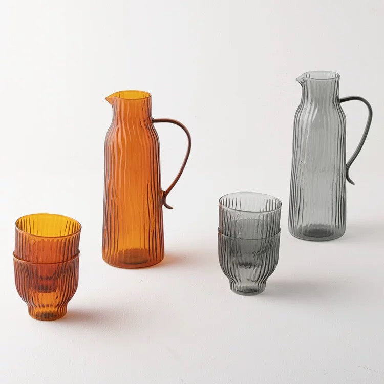 Glassware set with orange and gray pitchers and glasses on a white background, featuring the brand 'Alaniz'.