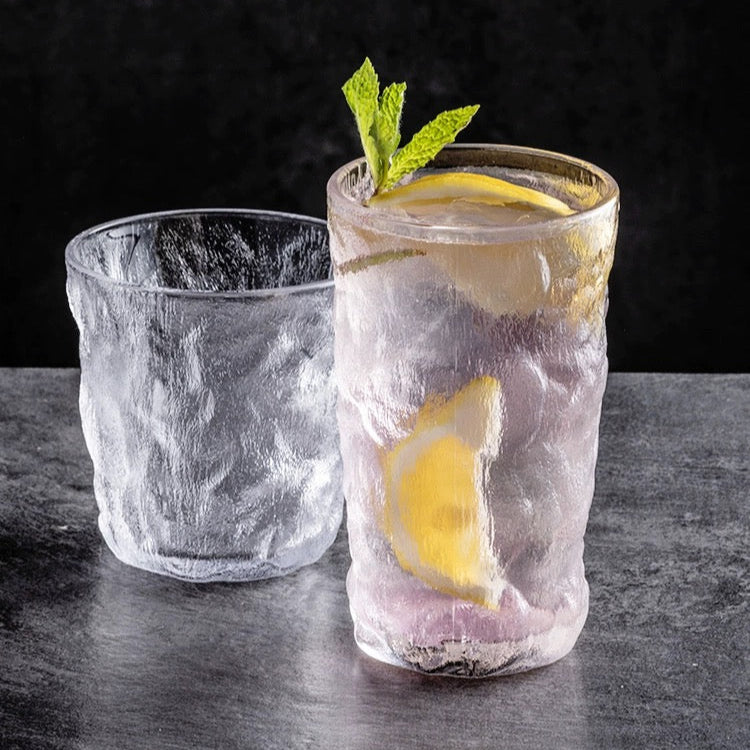 Two glasses with lemon slices and mint leaves on a dark surface, featuring the ALANIZ brand.