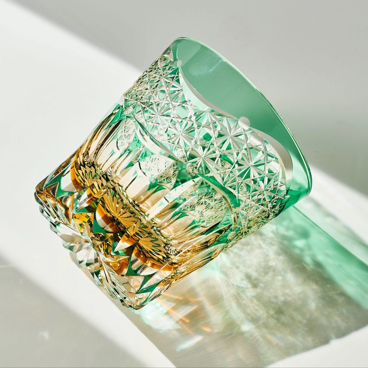 Decorative whisky glass container with geometric design on a light background